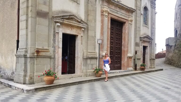Woman standing outside Chiesa di San Nicolo in Savoca Sicily