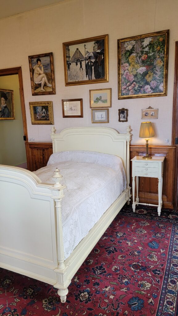Monet’s Giverny ~ Like Stepping into One of His Paintings! 23 Claude Monet's bed with pictures of Impressionist paintings.